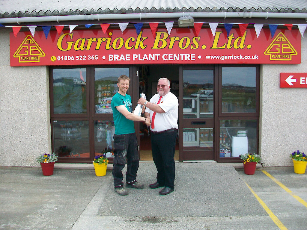 George Garriock presents the 1st customer (Stuart Hay) with a bottle of champagne